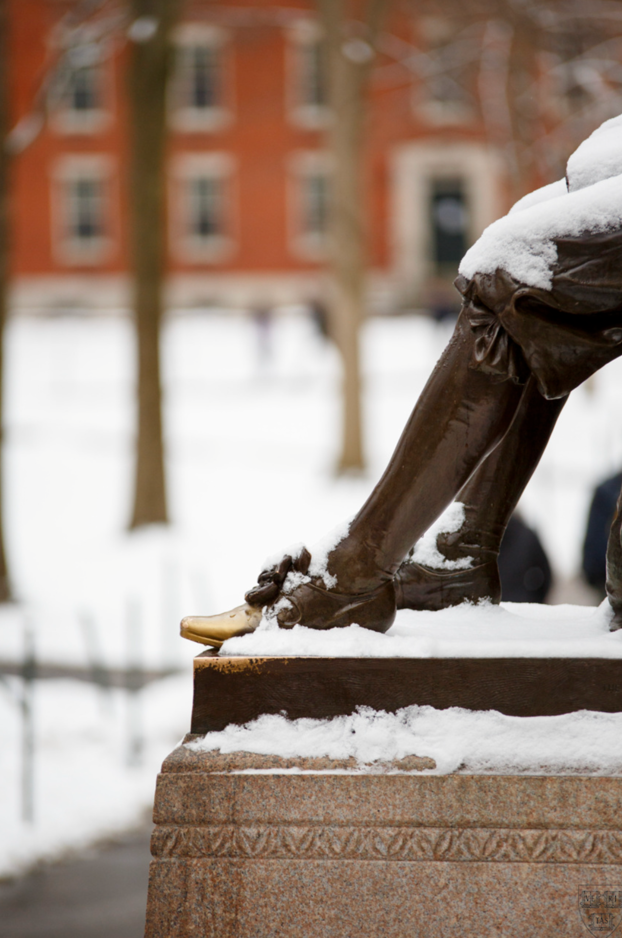 The John Harvard statue dusted in snow.