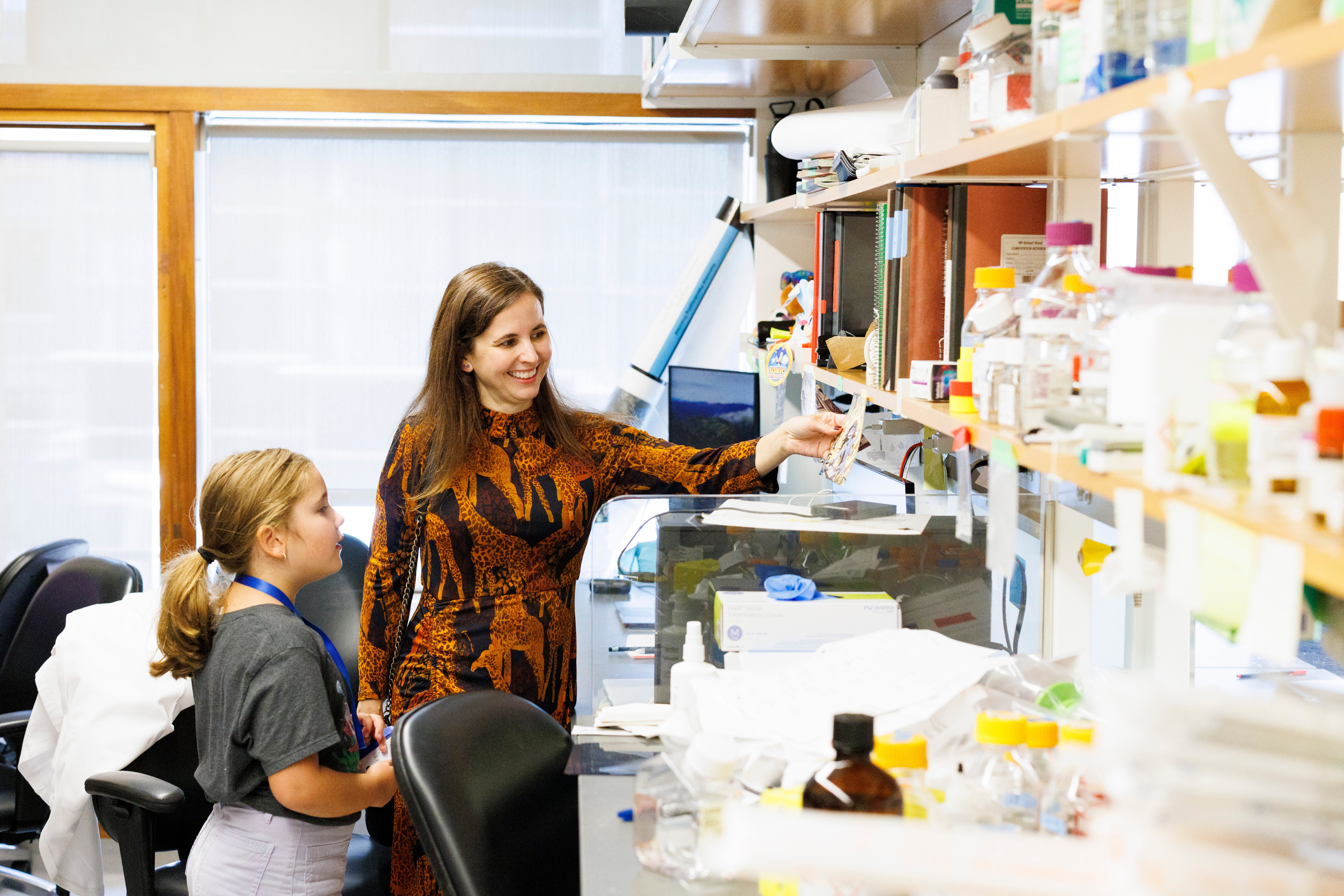 Professor Sarah Whited showing young donor, Marianne Cullen, around her lab.
