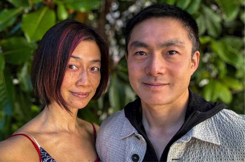 A current close-up photograph of Alfred and Rebecca Lin standing outside with trees behind them.