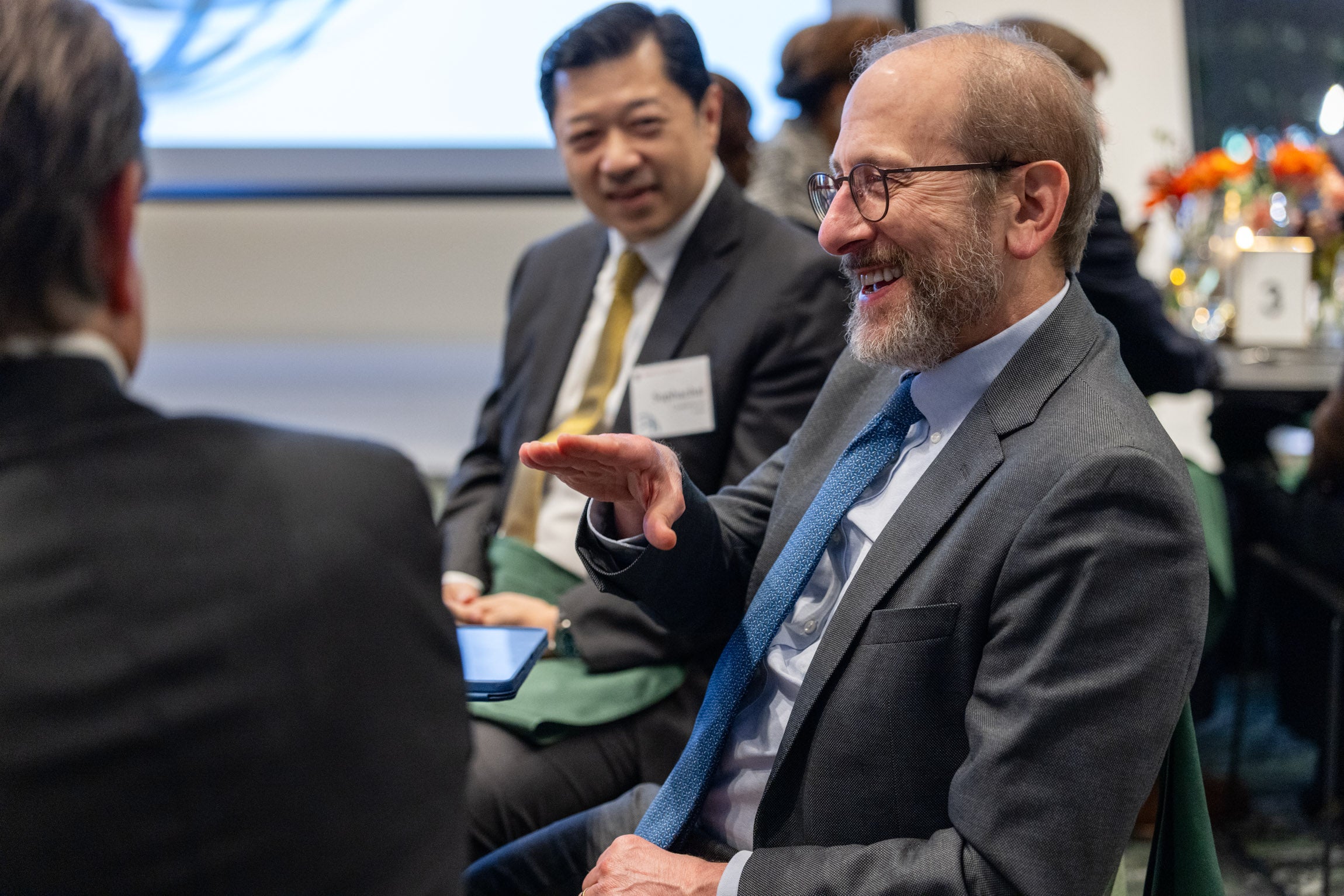 President Alan M. Garber speaks with fellow attendees over dinner at the 2025 Global Advisory Council meeting.