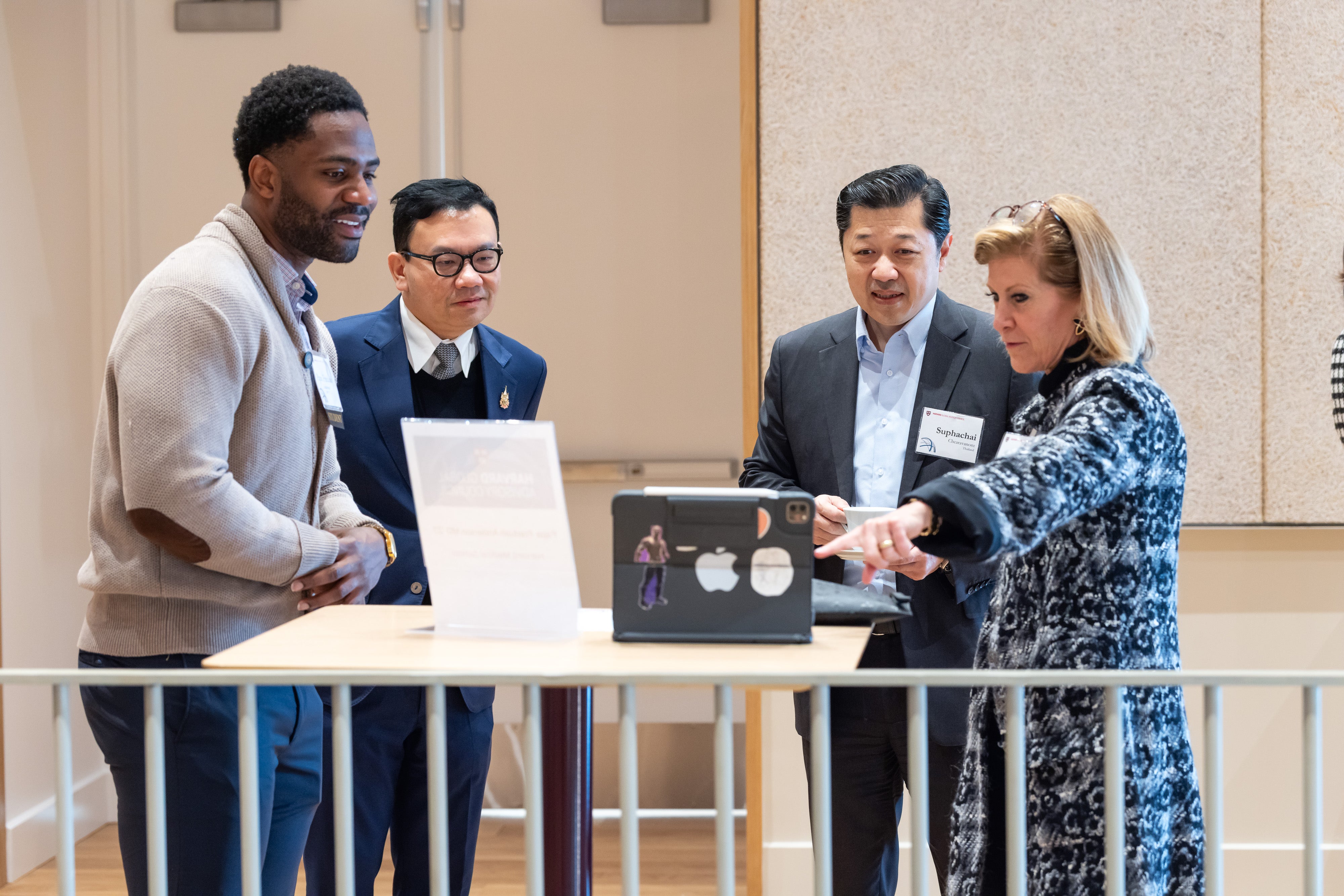 Mary C. Erdoes and Suphachai Chearavanont speak with a Harvard student at the 2025 Global Advisory Council meeting.