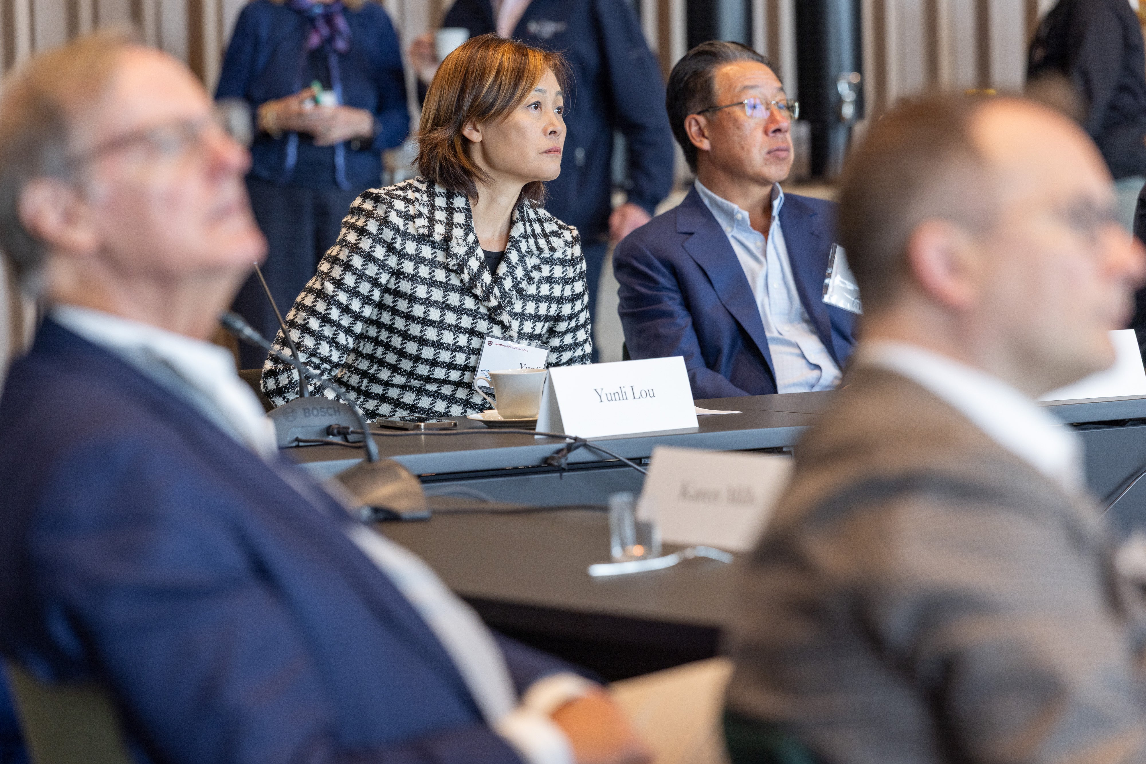 Yunli Lou, Xiang Dong Yang, and other attendees watch a faculty presentation at the 2025 Global Advisory Council meeting.