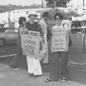 Protestors holding signs in support of equal rights for working women 