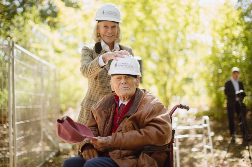 RoAnn Costin putting a hard hat on her father, Thomas P. Costin Jr., at the groundbreaking of Poplar Gate