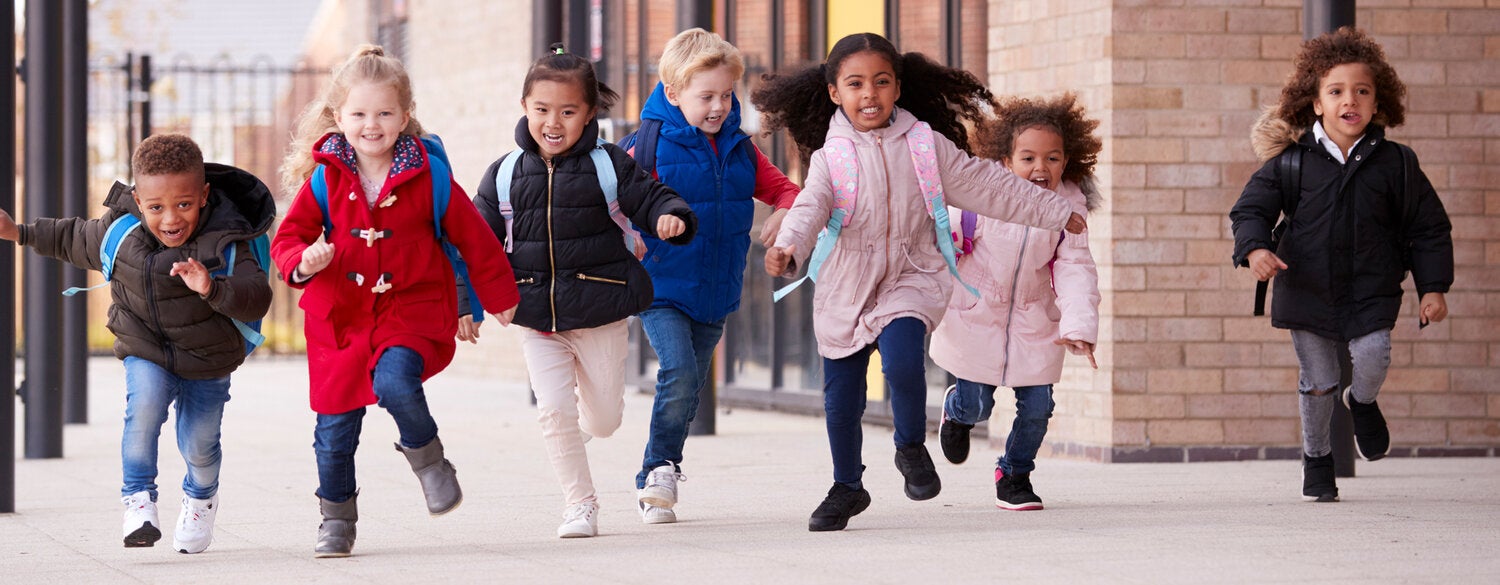 Group of young happy children running together