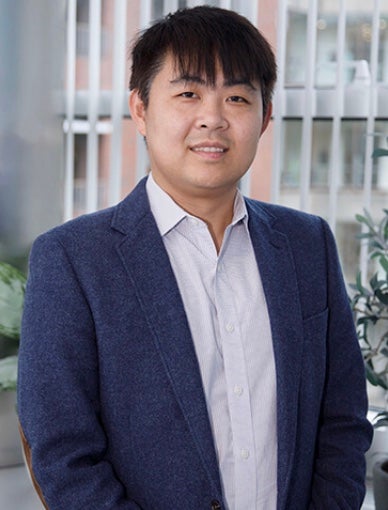 Asian man smiling wearing a suit