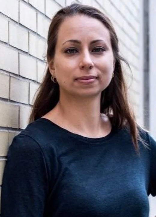 White woman with long brown hair and dark blue shirt