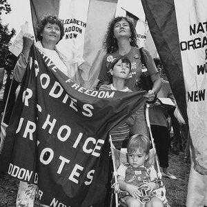 Women with young children holding a flag