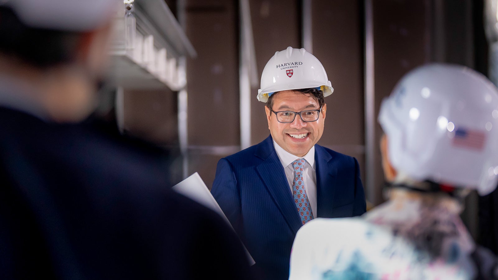 David Goel AB ‘93 wearing a hard hat and a bright smile as he and other COUR members tour the construction site for 60 Oxford Street, the new home of the Harvard Quantum Initiative