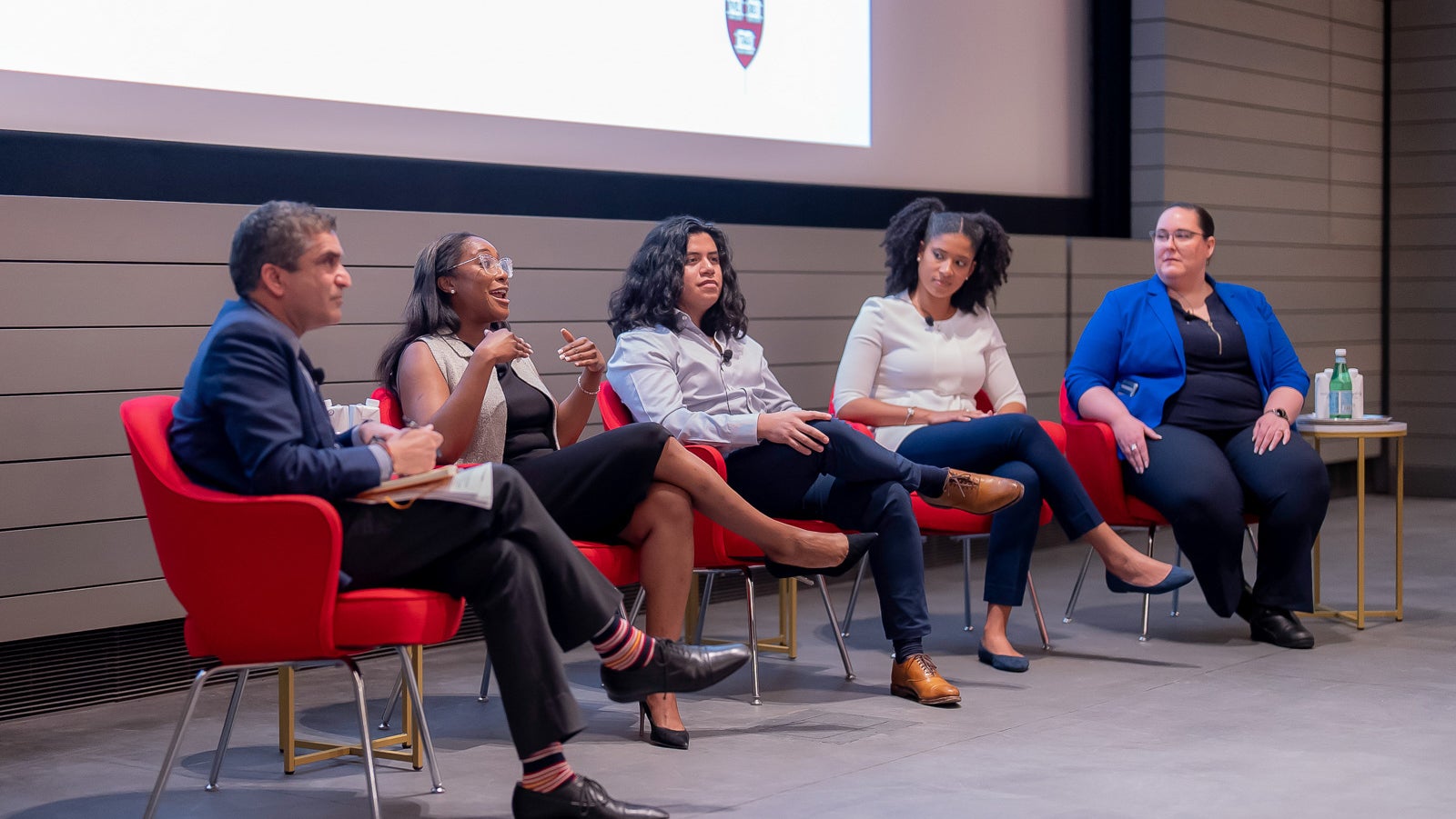 A photo featuring four panelists and Dean Rakesh Khurana PhD ’98, moderator, speaking at the first-generation Harvard alumni panel