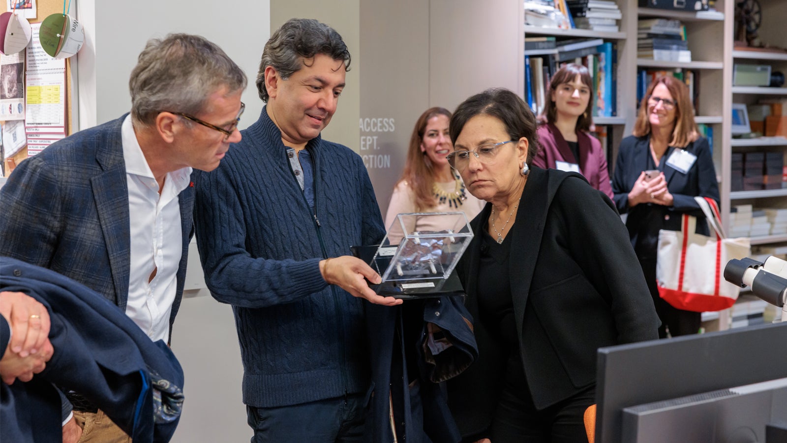 Global Advisory Council members examining a sample of Vantablack at the Straus Center for Conservation and Technical Studies.