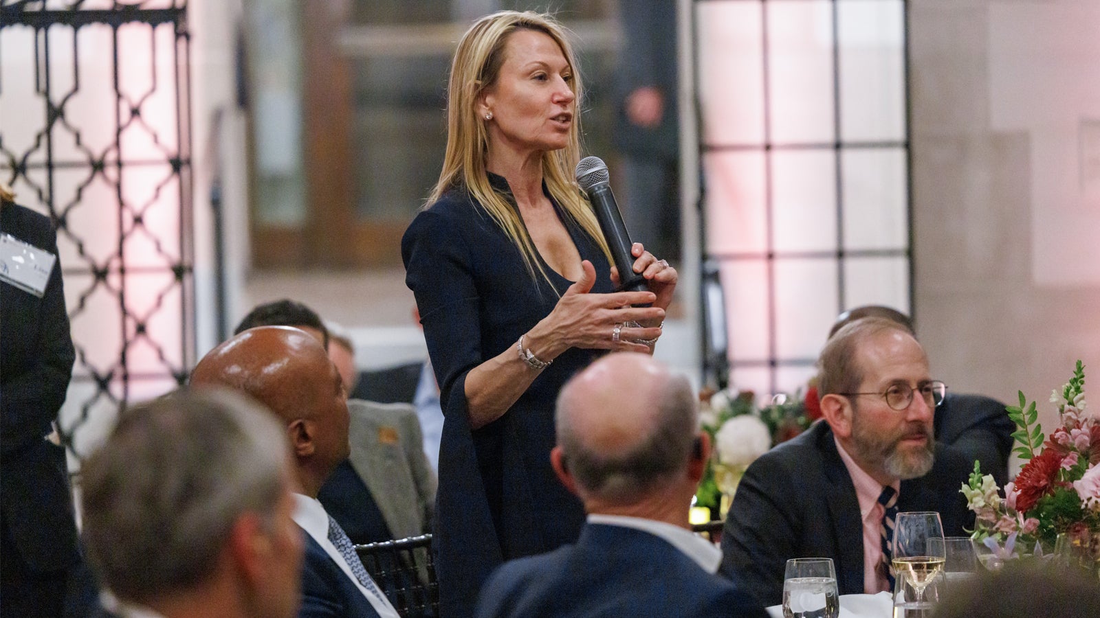 Suzanne Johnson asking a question to Harvard faculty members during the democracy panel at the 2024 Global Advisory Council meeting.