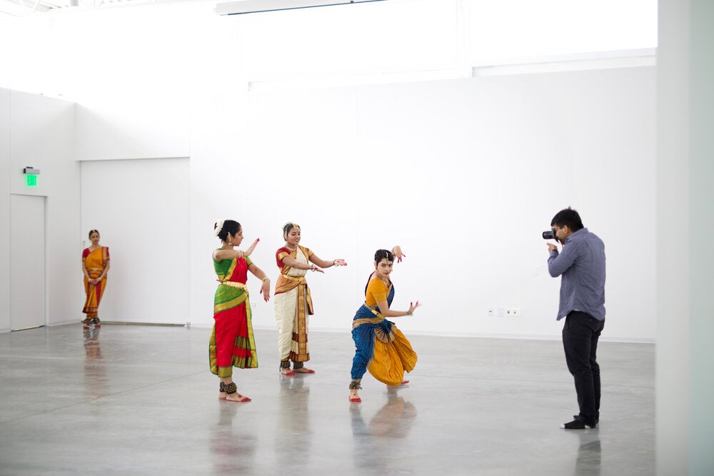 Man photographing cultural dance performance
