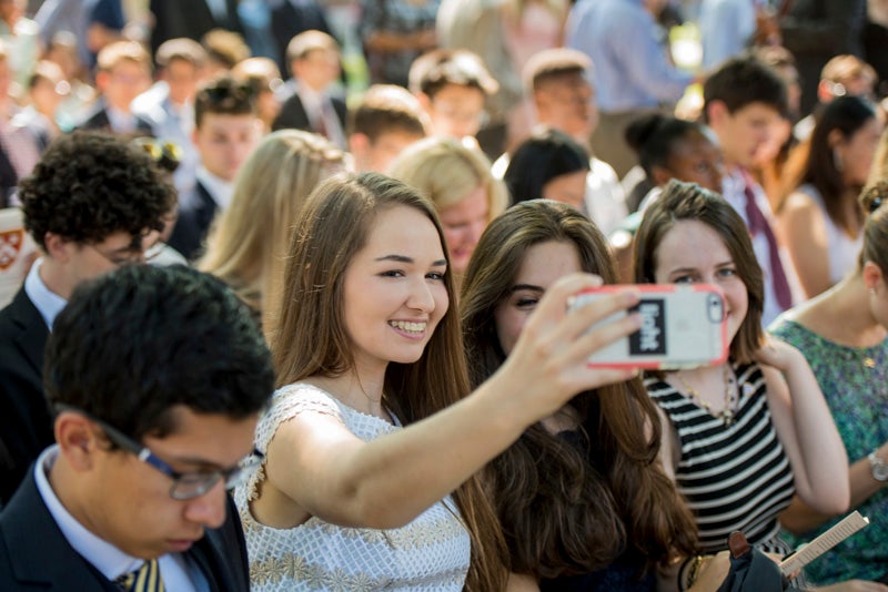 A student takes a selfie before the ceremony begins. 