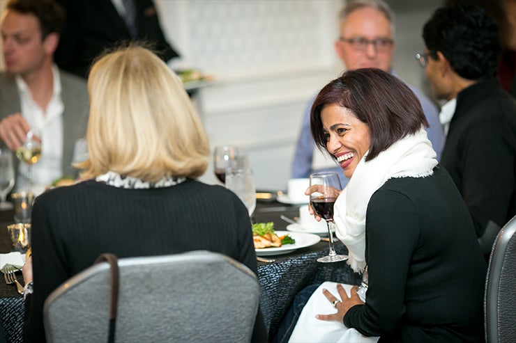 A guest laughs over dinner