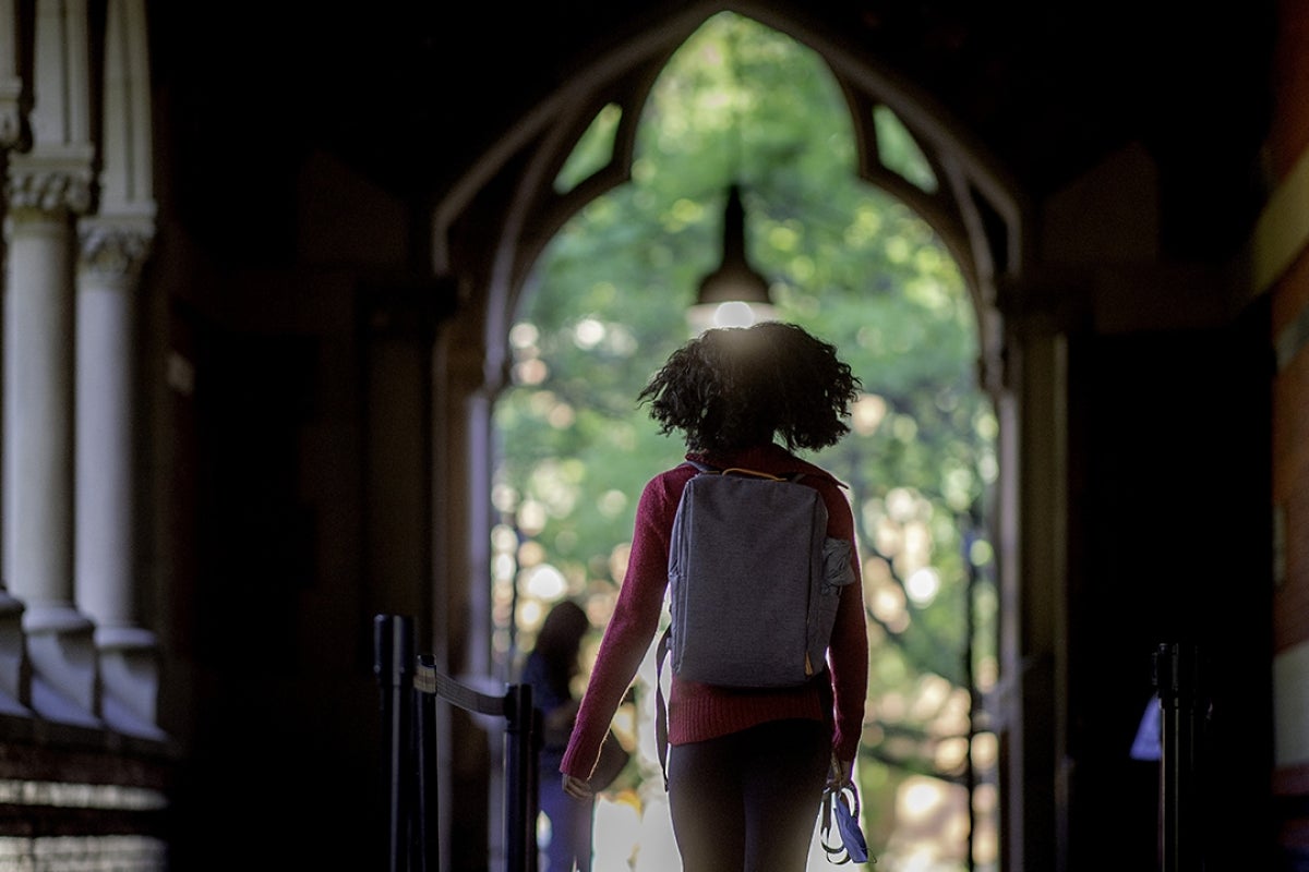 Image of girl wearing a backpack walking in Annenberg hall transept