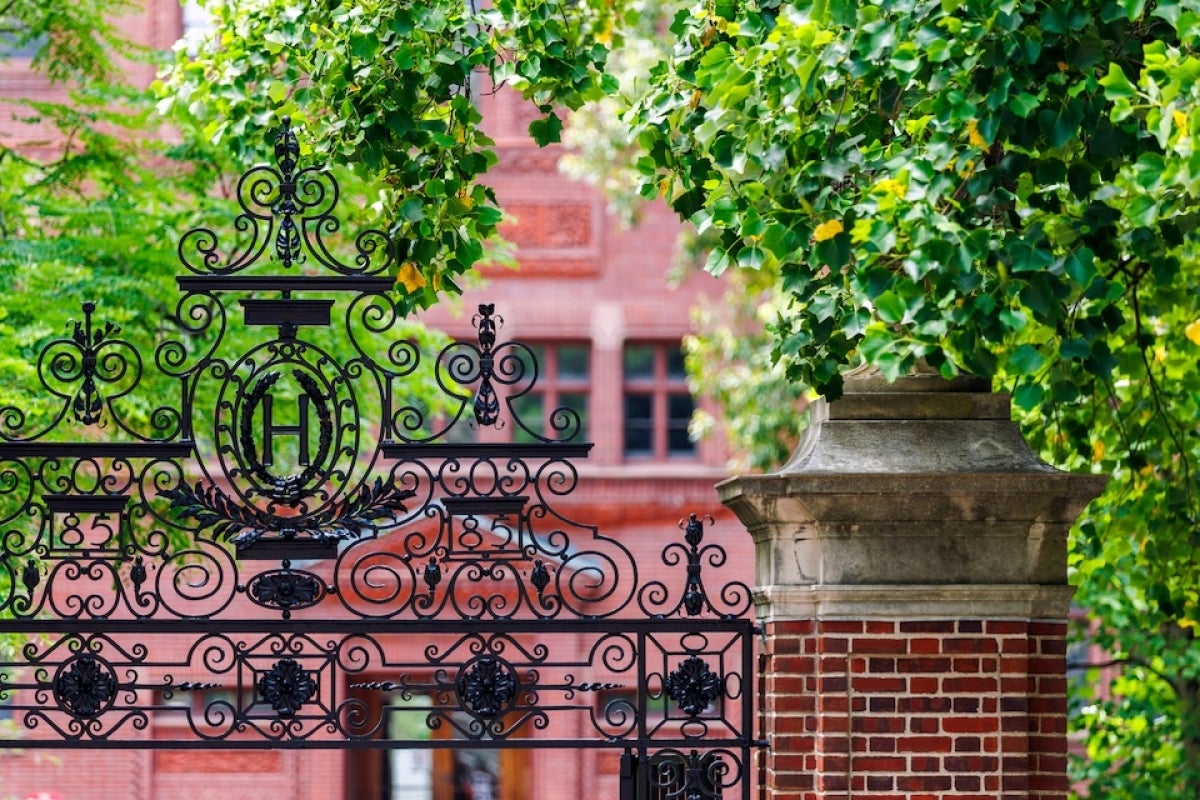 A gate in Harvard Yard with a red brick building in the background