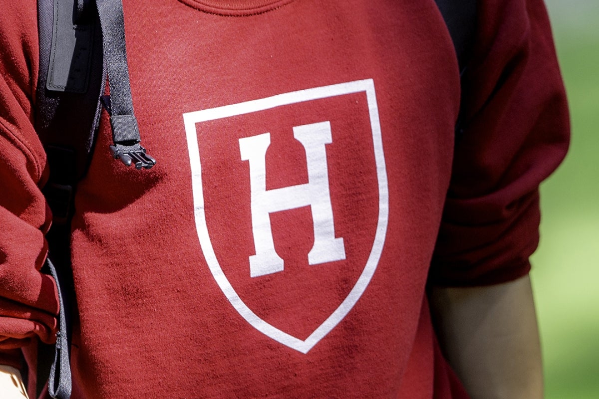 Image of student with backpack wearing a Harvard sweatshirt