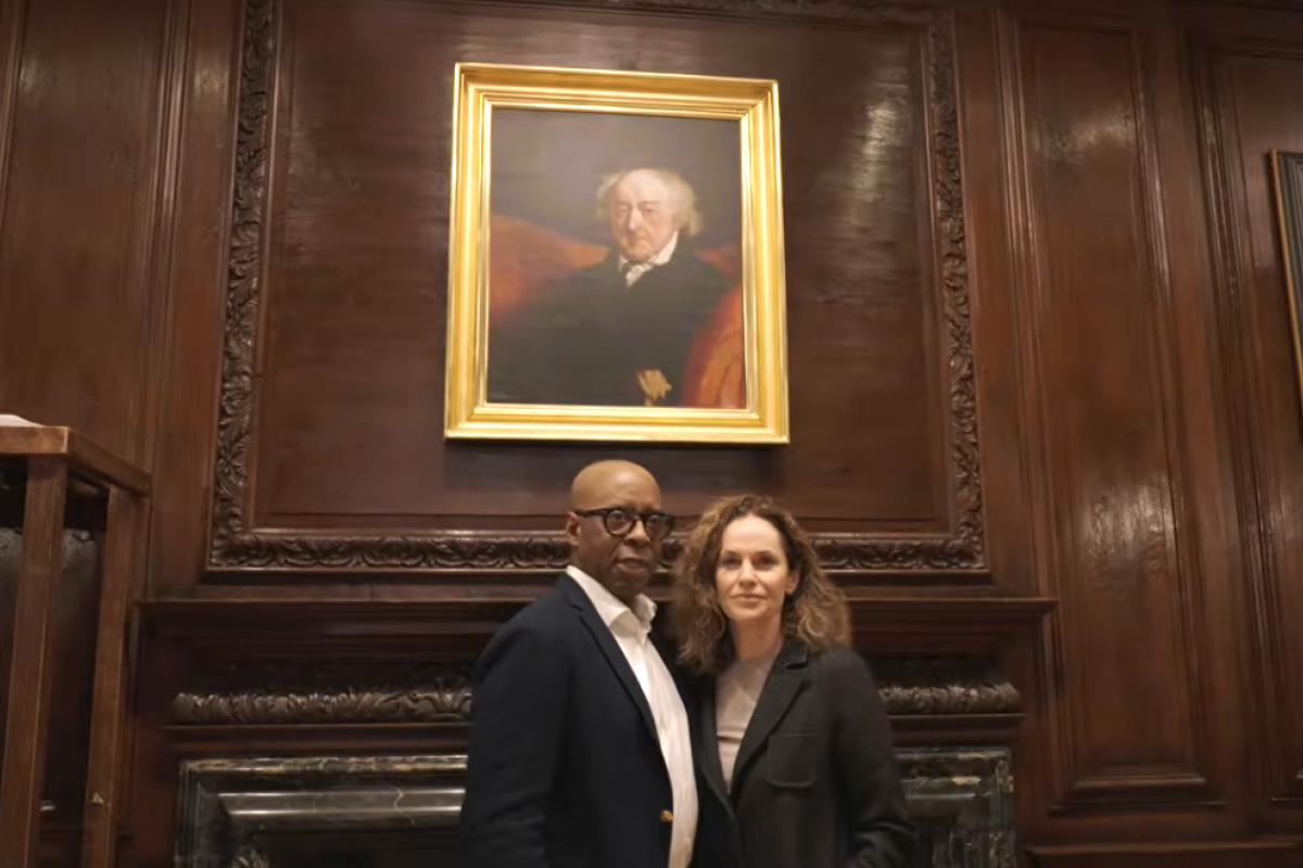 Courtney B. Vance and Amy Brenneman stand in front of a portrait of John Adams