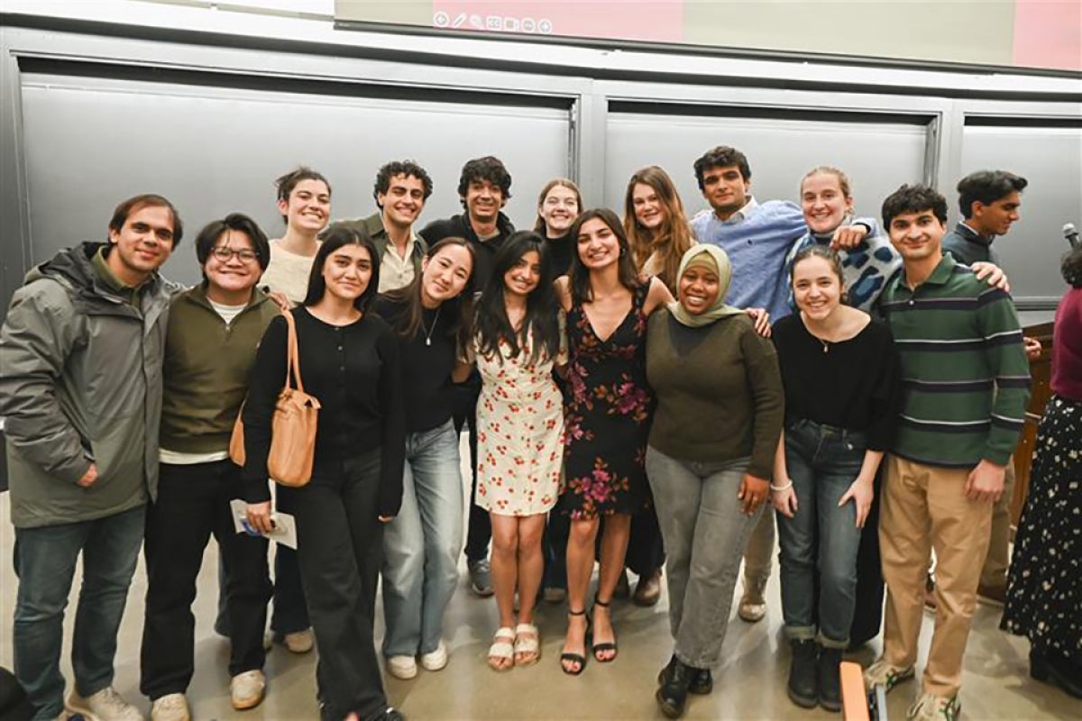 16 midyear graduates smile and pose.