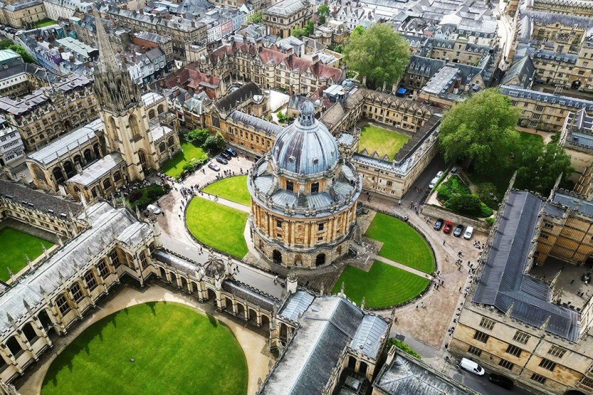 Aerial view of Oxford’s Radcliffe Camera surrounded by college buildings and green courtyards.