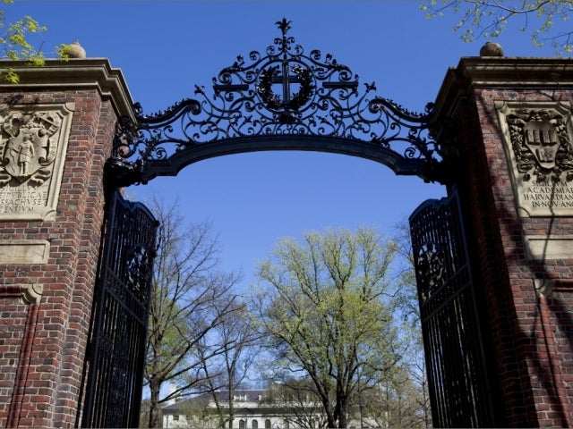 Open gates showing the buildings and trees inside Harvard Yard