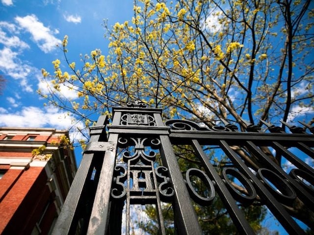 The gate along Quincy Street, featuring an "H" and Veritas shield