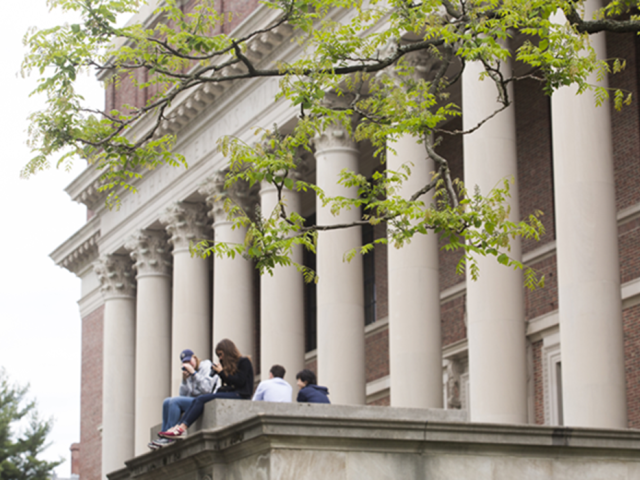 Two students sit on the steps of Widener Library