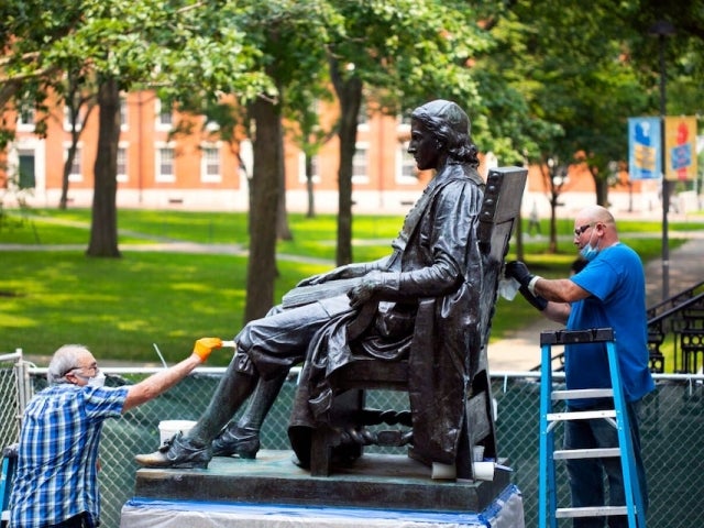 Robert Shure and Noe Magana work together on restorations to the John Harvard Statue.