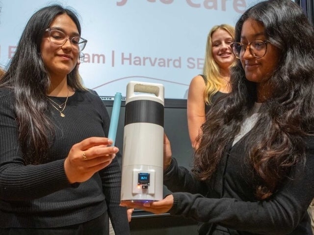 Two students demonstrate a temperature-sensing cooler for last-mile drug delivery 