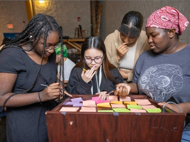 Four students review post it notes 