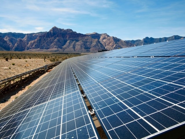 Solar panels in a Western landscape featuring mountains