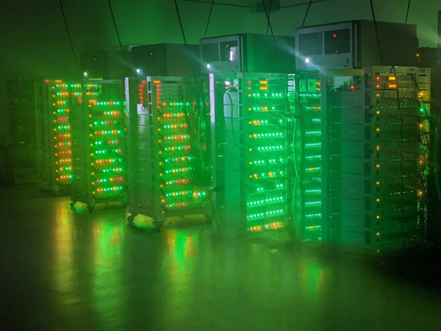 Large computer servers glowing with green light