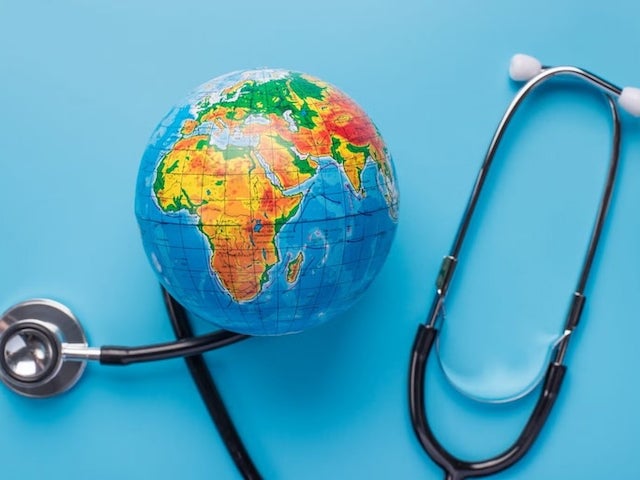  A stethoscope wrapped around a small globe on a blue background