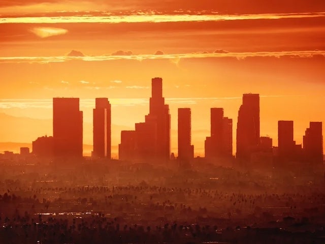 The silhouette of a city skyline under an orange-tinted sky