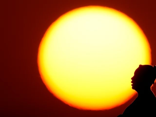 A woman was silhouetted against the setting sun 