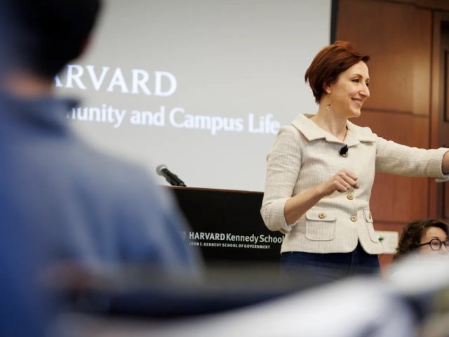 Julia Minson standing in front of a lectern in a classroom