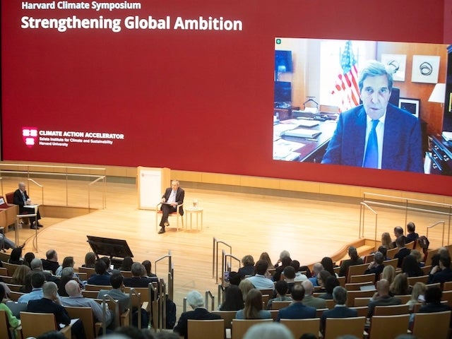 John Kerry on screen in conversation with Larry Bacow 