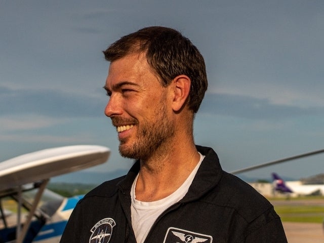 Kyle Clark on an airfield with a plane in the background