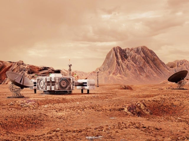 A futuristic building and satellite dishes are set up on a rocky, reddish landscape