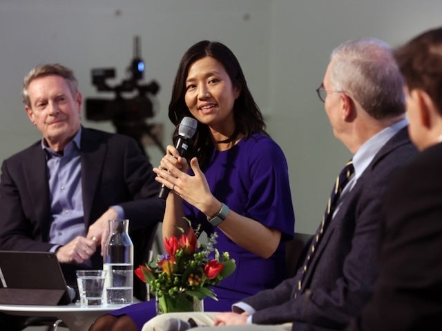 Boston Mayor Michelle Wu speaks into a microphone at a symposium