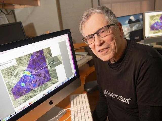  Steven Wofsy sits at a computer with a satellite image on screen