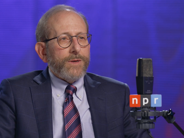 Alan Garber speaks with an NPR microphone in the foreground