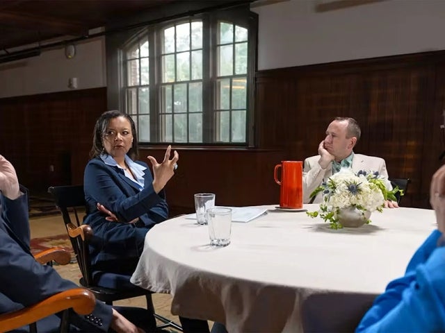 miko Brown-Nagin (center) and other scholars talk around a table