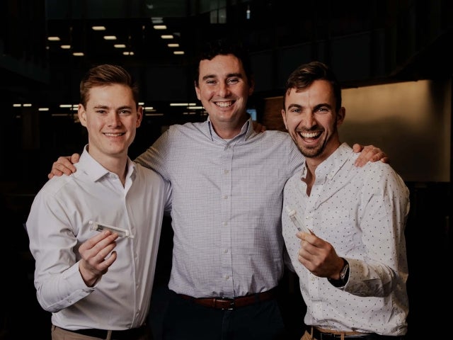 The Pacto Medical team smiles with samples of their product — a compact prefilled syringe.