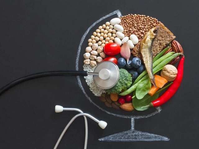 A globe composed of healthy foods with a stethoscope on top