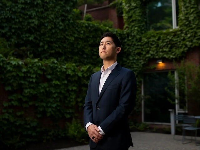 Rupen Dajee stands in front of an ivy-covered building