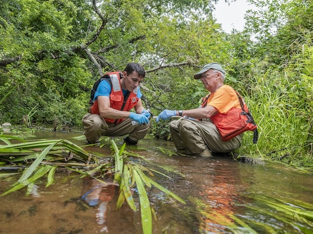 Bridger Ruyle and Denis LeBlanc collect water samples from the Santuit River on Cape Cod