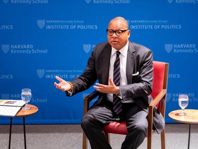 Wynton Marsalis speaks while seated in front of a blue Harvard Kennedy School Institute of Politics backdrop