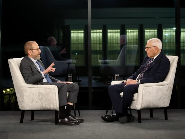 Alan Garber and David Rubenstein talking while seated in chairs